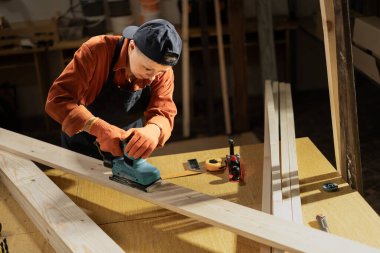 Milenyum kadın marangoz marangozluk atölyesinde zımpara makinesiyle odun öğütüyor. Marangozlukta çalışan elektrikli zımpara makinesi. Boşluğu kopyala