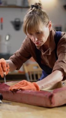 Yaşlı zanaatkar atölyedeki eski koltuğu tamir ediyor. Dikey video