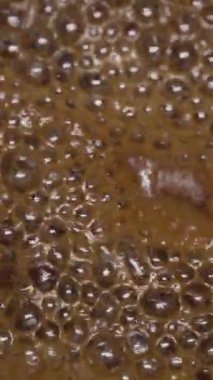 Karamel ve karamelizasyon yapan köpüklü kaynatılmış şekere yakın çekim. Şef kafede tatlı pişiriyor. Uzayı kopyala Dikey video