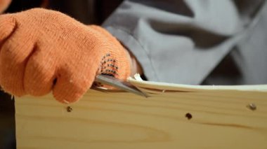 Ahşap işçiliğine yakın çekim, bir keski üst katmanı kaldırır, bir marangoz marangoz aletini kullanarak bir atölyede çalışır. Boşluğu kopyala