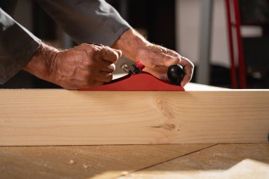 Marangoz atölyesinde marangoz ve kalas ile çalışıyor..