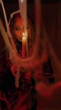 Cadılar Bayramı. Siyah dantel kıyafetli çekici bir cadı elinde mumla antik bir kalede duruyor. Esrarengiz vampir kadın..