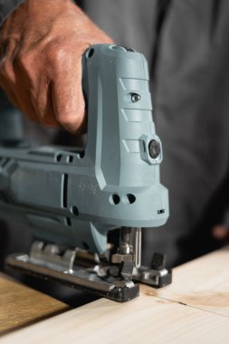 Yaşlı marangoz, atölyesinde testereli ahşap bir tahta görmüş. Boşluğu kopyala