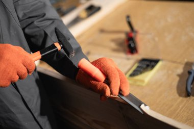 Marangoz atölyesinde çalışırken çekiç ve keskiyle tahta kesiyor. Yakın plan.