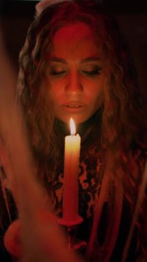 Portre, yakın plan. Cadılar Bayramı. Siyah dantel kıyafetli çekici bir cadı elinde mumla antik bir kalede duruyor ve büyülü sözler söylüyor. Esrarengiz vampir kadın..