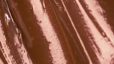 Yakın çekim makro karamelli çikolatanın zengin dokusunu vurguluyor. Detaylı görünüm, hoşgörülü katmanları ve parlak yüzeyleri yakalıyor ve şekerlemenin ustalığını vurguluyor..