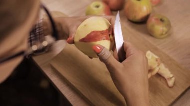 Meyve kırmızısını bıçakla soyan, yemek hazırlayan bir kadın. Sağlıklı beslenme konsepti. Yakın plan.