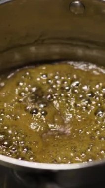 Baloncuklu kaynamış şekerin yakın çekimi karamelaya, karamelizasyona, kafede tatlı pişiren şefe dönüşür. Boşluğu kopyala