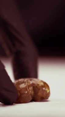 Hamur işi şefi kalp şeklindeki şekerlemeleri karamel ve fındıklı olarak yerleştirdi, ev yapımı şeker yapma konsepti. Dikey video