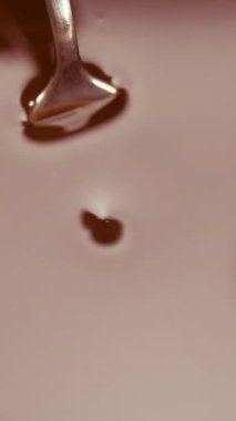 Çikolata jöleli çatalla kalp şeklinde şeker yapan bir aşçı. Şekerci, kaplamalı şekerler üretir. Dikey video