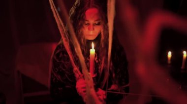 Siyah elbiseli genç cadı ellerinde yanan bir mum, okültizm ve sihir kavramını tutuyor. Boşluğu kopyala