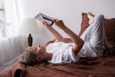 Huzurlu bir sabah rutini sırasında yatakta uzanmış kişisel günlüğünü okuyor, düşünceleri yansıtıyor, güne sakin bir şekilde başlıyor, günlüğü elindeyken sakin vakit geçiriyor. Boşluğu kopyala