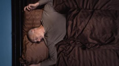 Uykusuzluk ve akıl sağlığı konsepti. Yaşlı adam kabustan muzdarip, korku içinde uyanıyor, kameraya kocaman gözlerle bağırıyor. Boşluğu kopyala