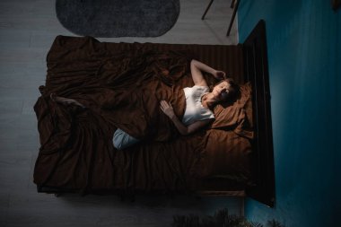 En üst kat yatak odası manzaralı. Orta yaşlı bir kadın geceleri rahat bir şekilde uyuyor. Bayan verimli bir gün için dinleniyor. Üst görünüm