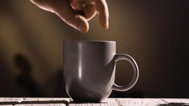 El, çay ya da kahveye küp şeker atar. Şeker fincana düşer. Kafein bağımlılığı. Boşluğu kopyala