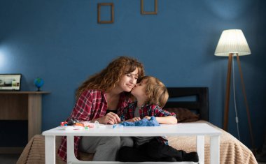 Anne çocuğunu öpüyor evde oğluyla vakit geçiriyor. Boşluğu kopyala