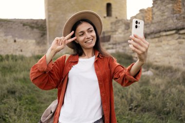 Antik şatoda selfie çekerken akıllı telefon kullanan kadın turist. Boşluğu kopyala.