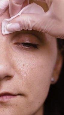 Usta kızların kaşlarını emici pamuk süngerle siler. Kalıcı kaş makyajı ve kahverengi pigmentle dövme. Boşluğu kopyala