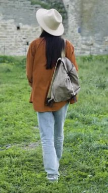 Eski şatoda seyahat eden şapkalı bir kadın turist, Avrupa 'da tatil kavramı. Yüzü olmayan arka plan.