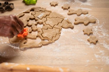 Erkek Eller kırsal masada zencefilli ekmek hamuru kesiyor, yakın çekim. Yaşlı bir adam Noel kurabiyesi yapıyor. Boşluğu kopyala