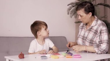 Bebek ve annesi plastikten figürler yaparak evde oynuyorlar. Geliştirme ve öğrenme kavramı. Boşluğu kopyala