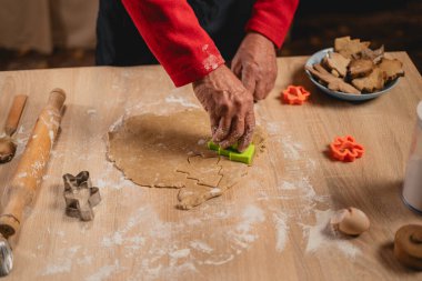 Noel ve Yeni Yıl gelenekleri. Mutfakta Noel pastanesi var. Zencefilli ekmek yapan, zencefilli ekmek hamuru kesen bir adam. Yemek pişirme ve aile aşçılığı. Üst görünüm