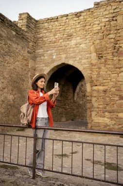 Kadın, sosyal medya için cep telefonunda resim yapan Kale antik mimarisini ve tarihi kuleleri keşfediyor. Boşluğu kopyala
