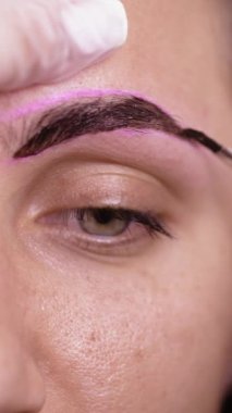 Makyaj sanatçısının yakın çekimi kaşlara boya sürüyor. Profesyonel makyaj konsepti