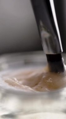 Kaş mürekkebi, cam bir kavanozda oksitleyici ile karıştırılmış, kaş boyama için hazırlanıyor. Dikey video. Yakın plan.