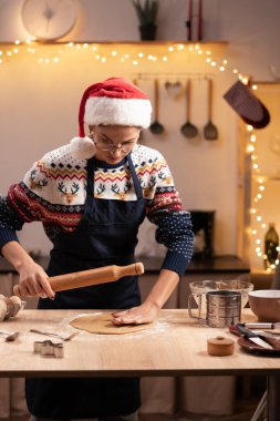 Evde Noel için zencefilli ekmek yapmak için hamur hazırlayan kadın portresi. Ev hanımı tatil için arkadaşlarına pasta yapıyor. Boşluğu kopyala