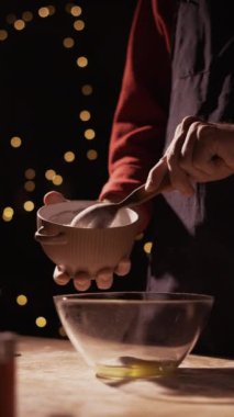 Erkek hazırlığı bayram yemeği. Erkek aşçı dekore edilmiş mutfakta kurabiye pişiriyor, zencefilli kurabiye için hamura şeker döküyor. Boşluğu kopyala