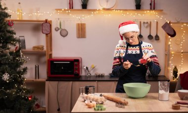 Evde Noel pastası. Noel Baba şapkalı kadın ev mutfağında zencefilli kurabiye hamuru pişiriyor. Boşluğu kopyala