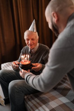 Yetişkin oğlu olan yaşlı bir baba doğum gününü evde kutluyor. Adam ona bir pasta verdi, mutlu bir aile yarattı. Boşluğu kopyala
