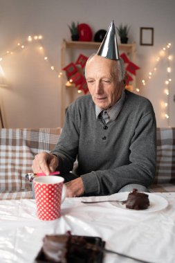 Doğum günü, depresyonlu üzgün yaşlı adam, evinde yalnız. Yaşlı bir insan hayal kırıklığıyla dolu bir partide yalnız, hayal kırıklığına uğramış ya da rahatsız edilmiş bir şekilde oturma odasında oturuyor. Boşluğu kopyala