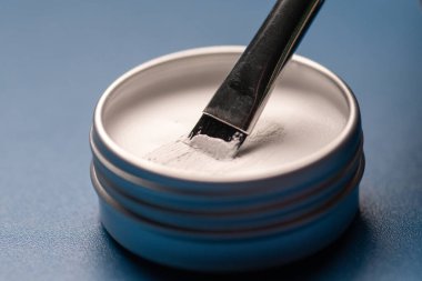 Kaşların şeklini işaretlemek için beyaz macun ve fırça, yakın plan. Profesyonel makyaj ve yüz bakımı. Boşluğu kopyala