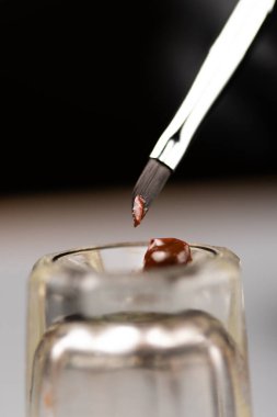 Kaş boyasını karıştırmak için cam bardağa boya sürdüm. Yakın plan.