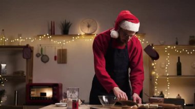 Noel arifesinde mutfakta zencefilli kurabiye yapan bir adam yemek kitabı okuyor ve tatil için yemek tarifi arıyor. Noel yemeği konsepti