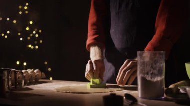 Noel kurabiyesi yapma süreci. Zencefilli kek ağaçları, adam küfle kurabiye kesiyor. Alçak tuş