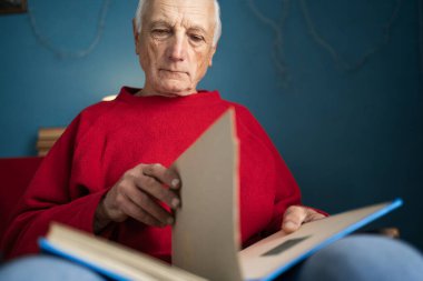 Elinde fotoğraf albümleri olan dul bir adam ve ölmüş karısını hatırlıyor. Yakın plan.