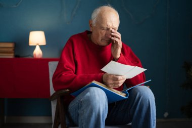 Elinde retro fotoğraflarla elinde fotoğraf tutan ağlayan yaşlı bir adamın portresi kayıp gençliği anımsıyor. Anılar ve nostalji kavramı.