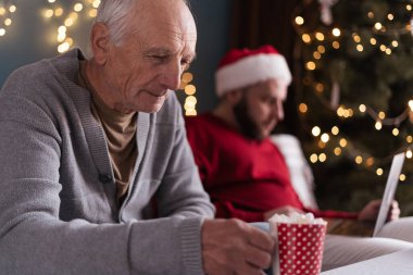 Büyük baba, oğlu Noel boyunca işine odaklandığı için kendini soyutlanmış hissediyor. Yaşlı adam, yalnızlık duygusuyla, içkisini tutar.