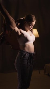 Beyaz bir kadın akşam yürüyüşüne hazırlanıyor. Evde giyiniyor. Kahverengi bir gömlek giyiyor. Boşluğu kopyala