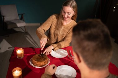 Genç bir çift akşamları evde yemek yiyor, aşık bir adam ve kız pasta yiyor yıldönümünü veya sevgililer gününü kutluyorlar.