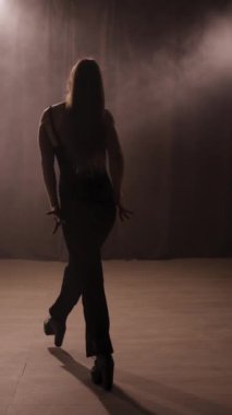 Dans stüdyosundaki dans stüdyosunun zemininde dans eden, serbest dans hareketleri yapan genç bir kadının yakın çekimi. Boşluğu kopyala