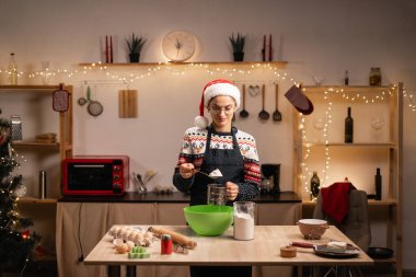 Aşçılık eğitimi sınıfı konsepti. Ev yapımı fırıncı mutfakta zencefilli kurabiye yapıp kameraya Noel videosu çekiyor. Boşluğu kopyala