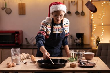 Evde geleneksel hamur işleri hazırlayan, tatil için zencefilli kurabiye pişiren genç bir kadın. Boşluğu kopyala