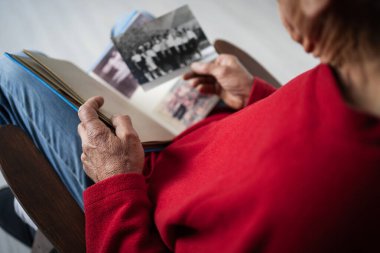 Yaşlı adam elinde çocukluk fotoğraflarının olduğu siyah beyaz bir albüm tutuyor. Mutlu anılar, nostalji konsepti.