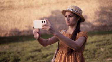 Uzun saçlı güzel bir kadın eski kalede selfie çekiyor. Fotoğrafçı, yazın seyahat ederken seyahat blogu için fotoğraf çekiyor. opy hızı