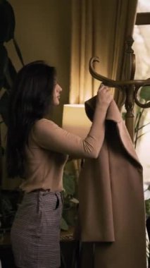 Esmer kadın ağır çekimde kalın bir palto giyiyor. Boşluğu kopyala