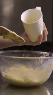 Şekerci cam karıştırma kabında choux hamur hazırlıyor. Kraker ve hamura yumurta ekleme. Adım adım ekinlerin tarifi. Boşluğu kopyala
